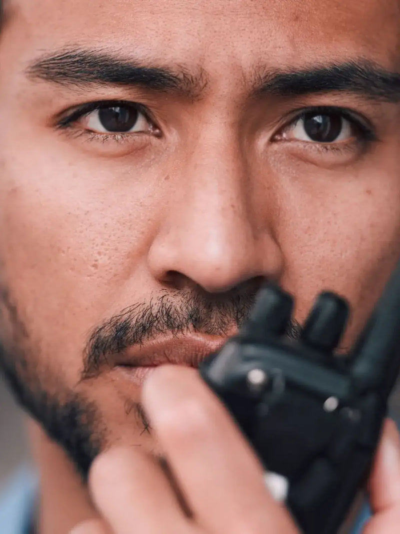 Agent_de_securite_avec_talkie_walkie_dans_la_main_en_gros_plan_sur_son_visage