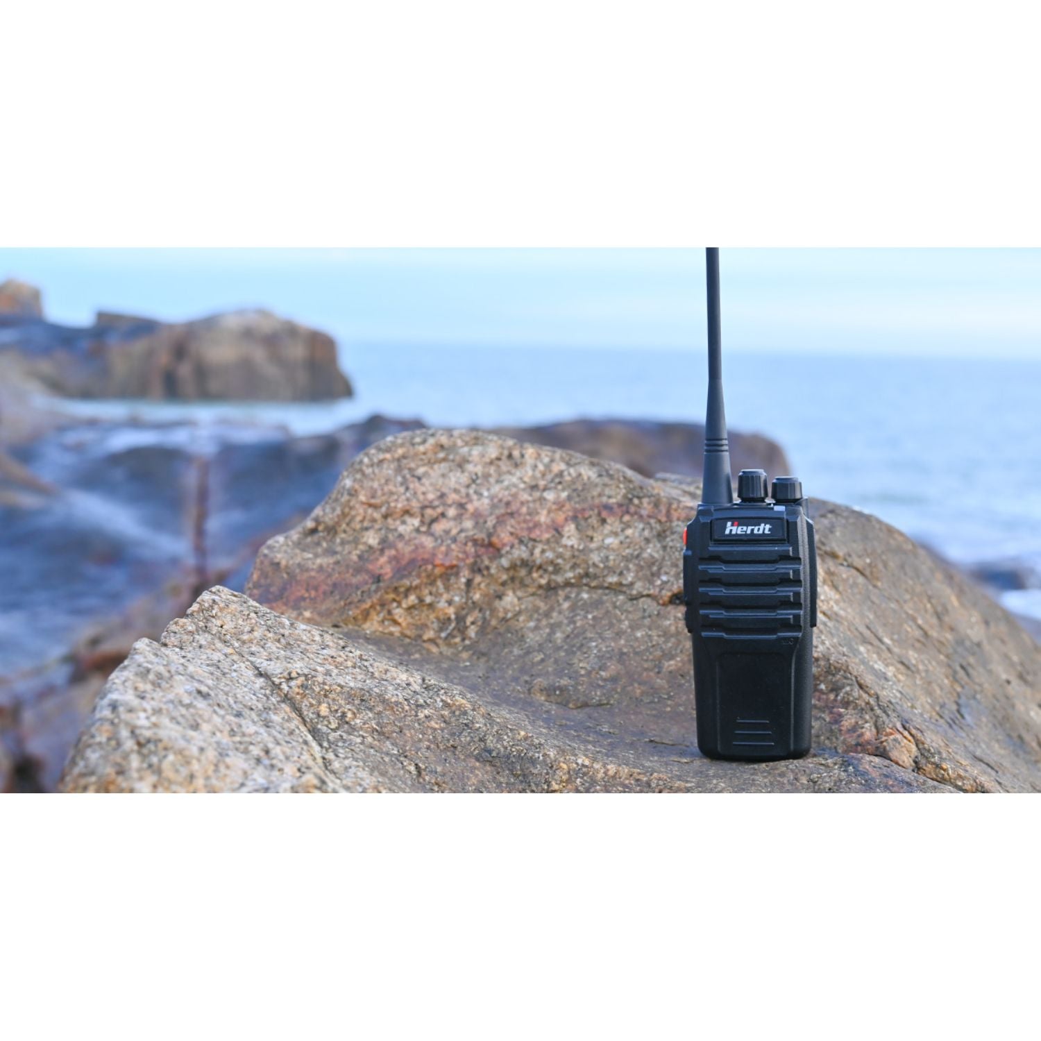 Talkie walkie posé sur rocher devant l'océan